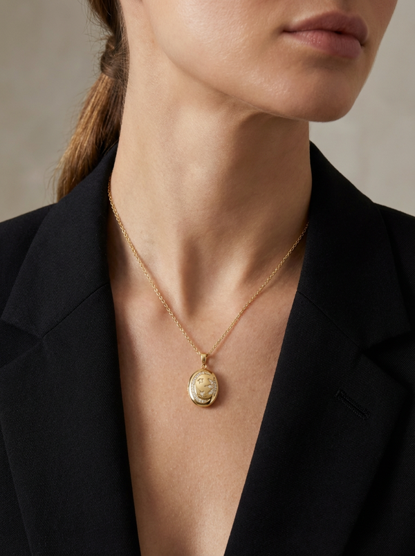 Zarif Violet Kolye'nin paslanmaz çelik zinciri, oval formlu kapaklı tasarımı ve taşlarla işlenmiş hilal ve yıldız figürleriyle gökyüzünün ışıltısını yansıtıyor.